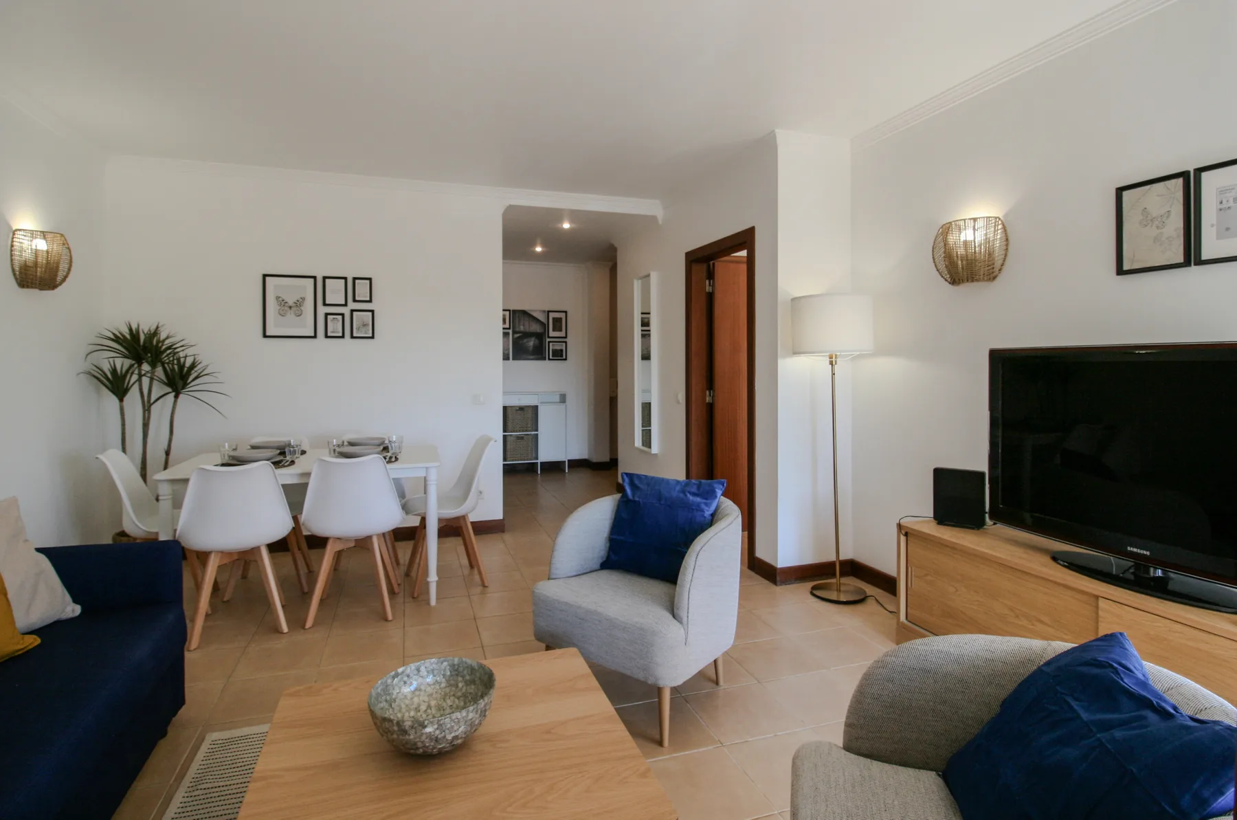 A living and dining area with a television and blue seating.