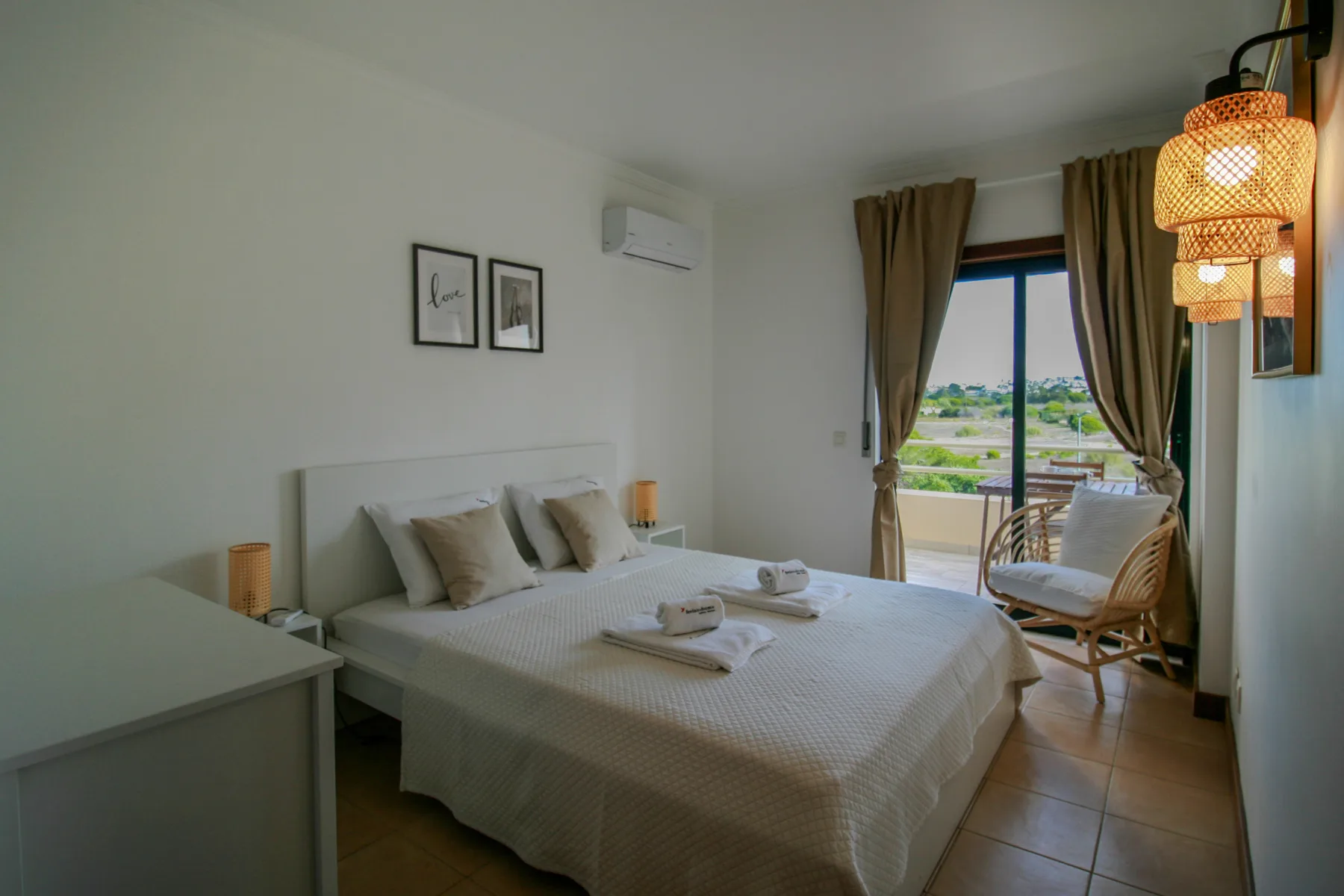 A bedroom with a double bed and an open balcony door.