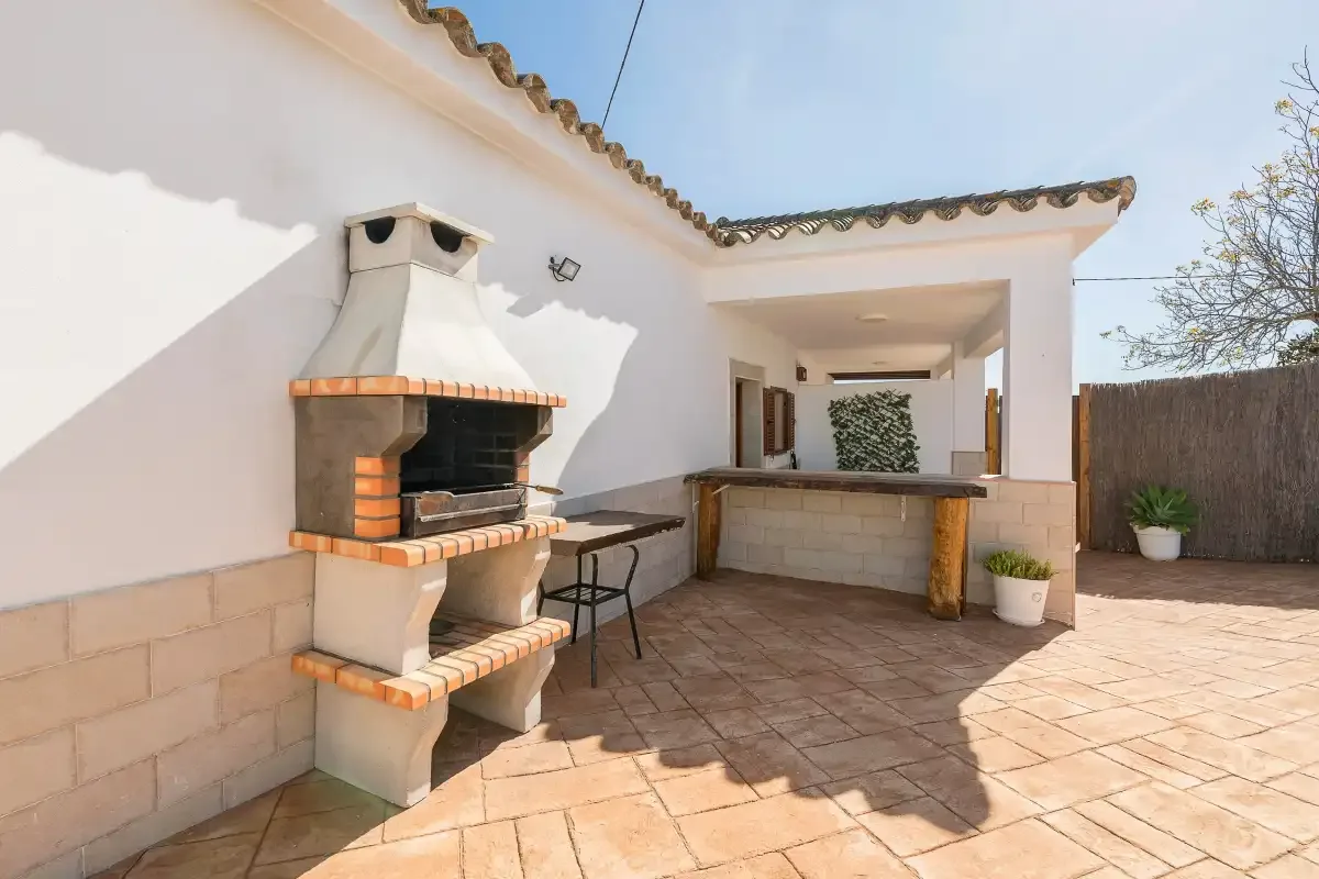 An outdoor patio features a built-in barbecue and a counter.