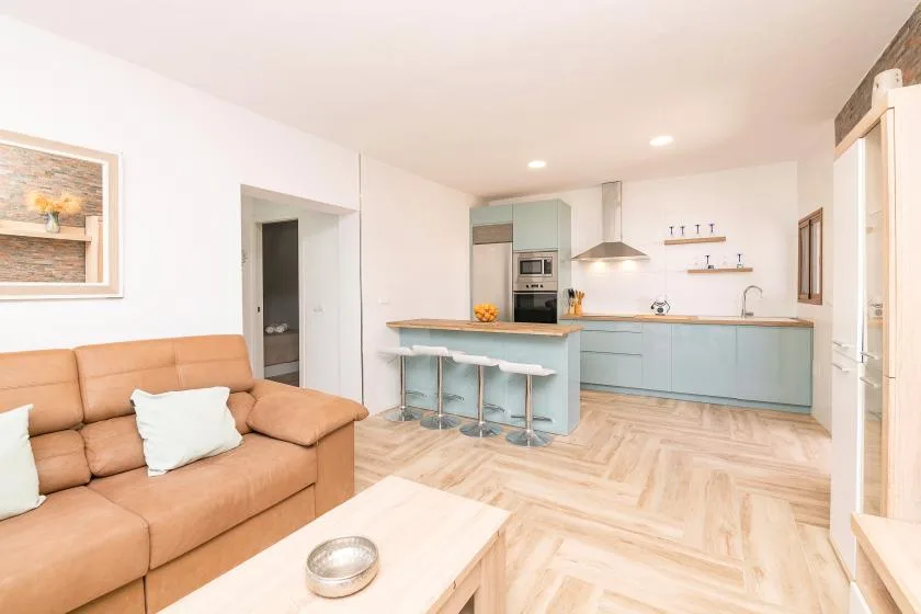 An open-plan living room and kitchen with a counter and seating.