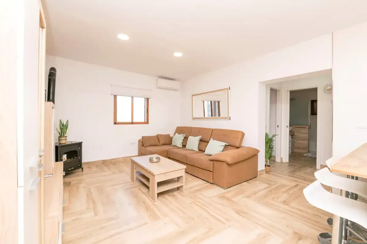 A bright living room with seating, a coffee table, and a window.