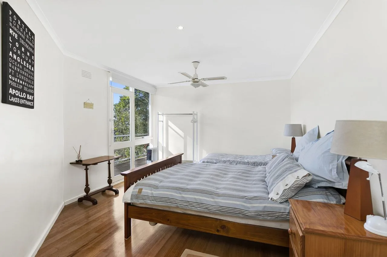 Un dormitorio luminoso con una cama grande junto a una ventana.