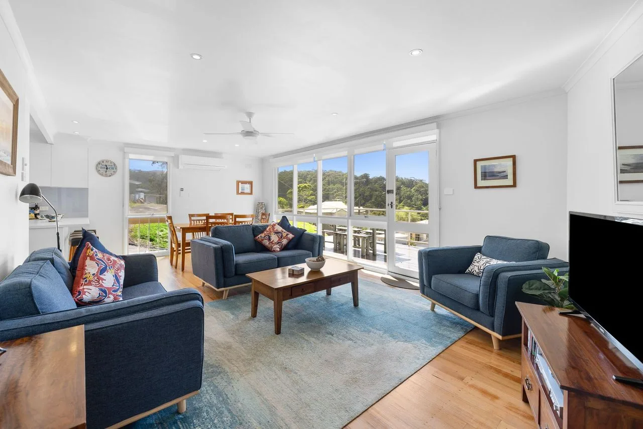 A bright living room with seating arranged around a coffee table.