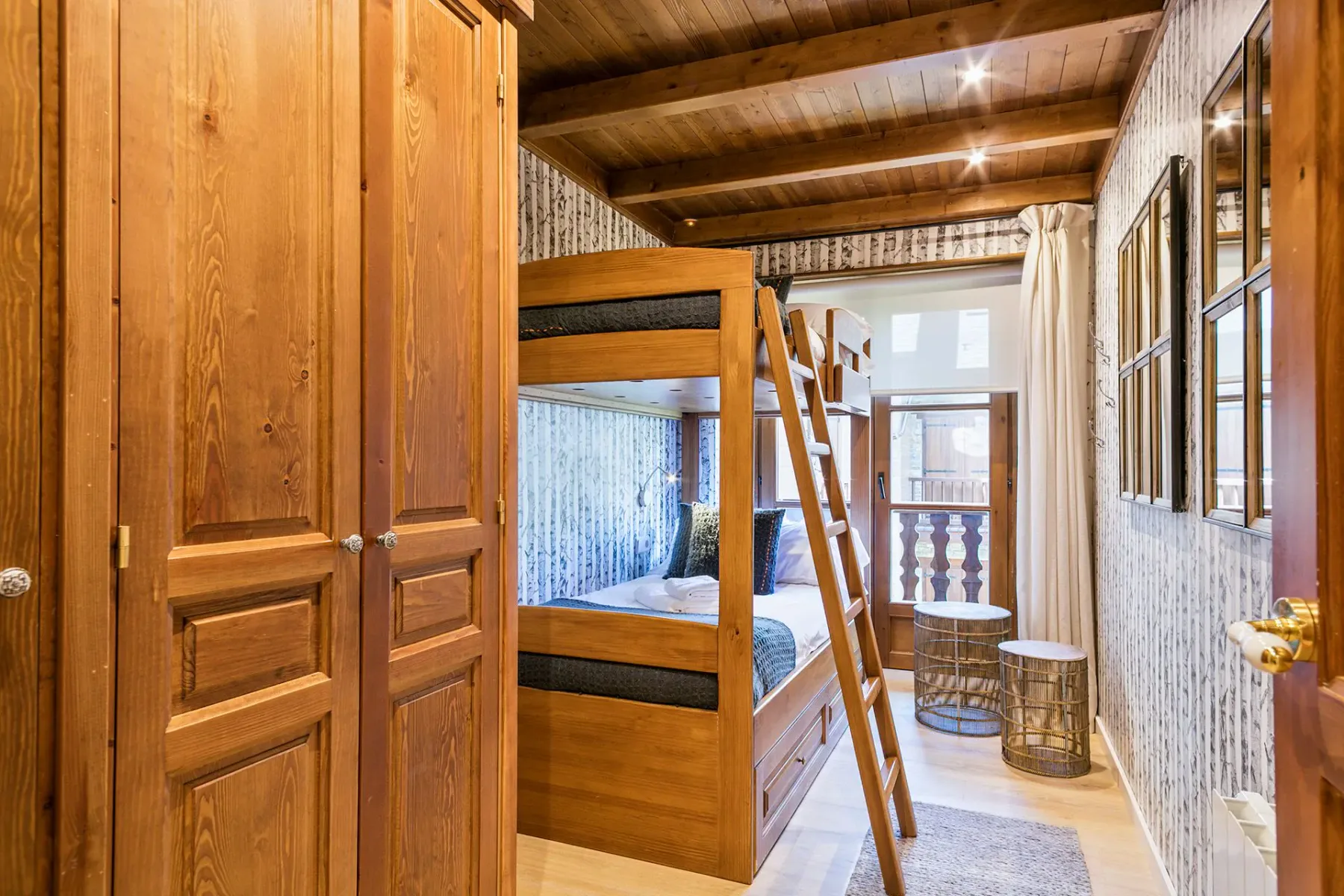 A wood-paneled bedroom with bunk beds and a ladder.