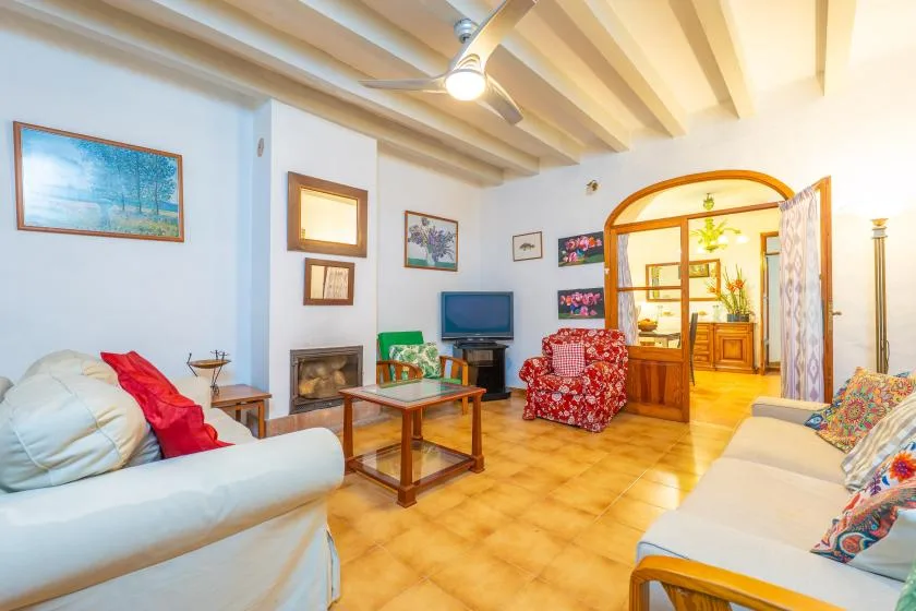 A bright living room with seating, a coffee table, and an arched opening to the next room.