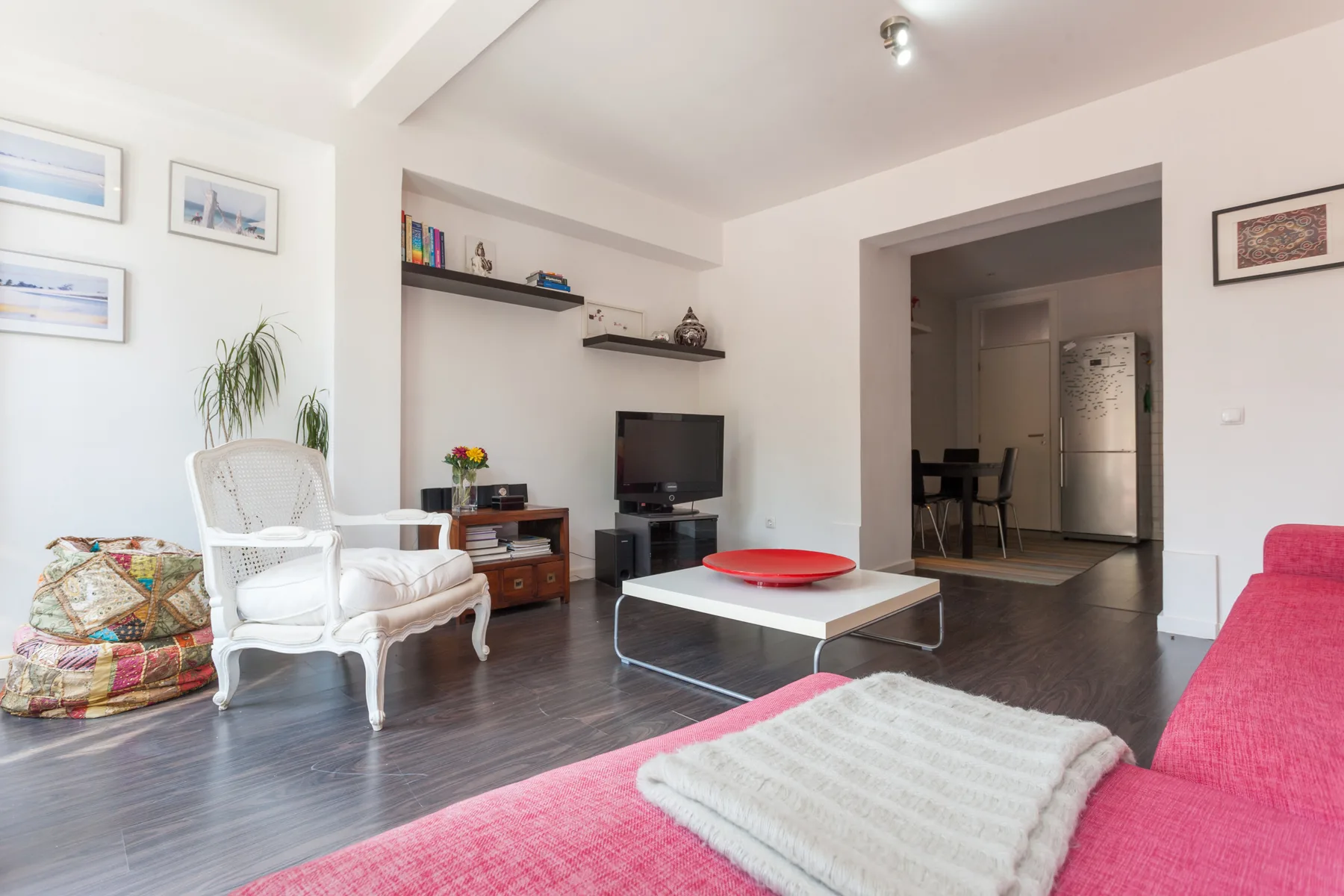 Sala de estar con asientos, un televisor y una mesa de centro baja.