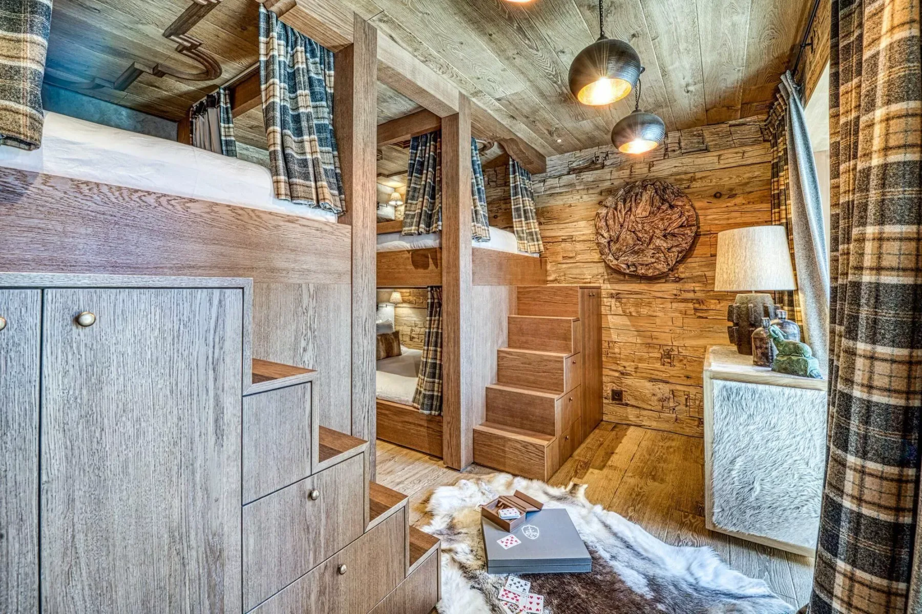 A rustic wood-paneled bedroom with a raised sleeping area and steps.