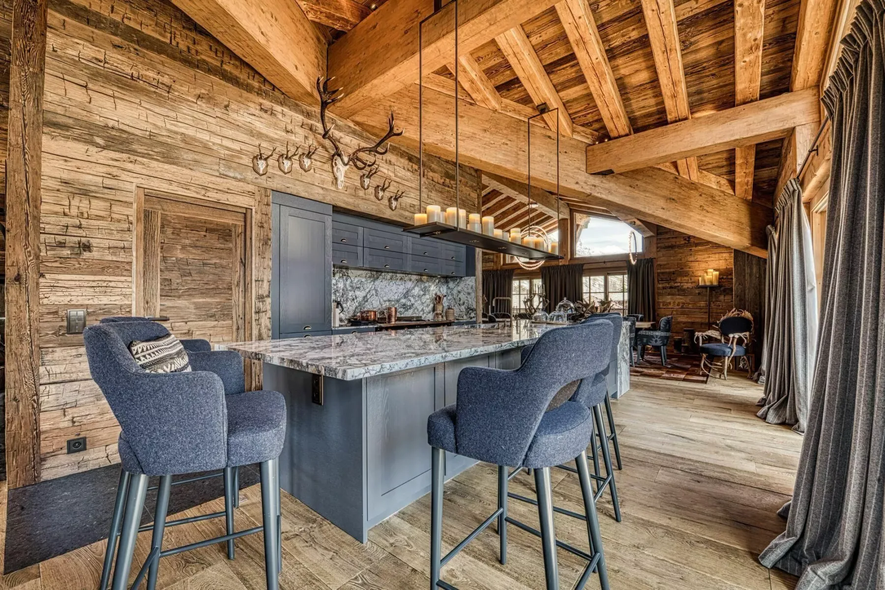A rustic kitchen and dining area with a large island and blue seating.