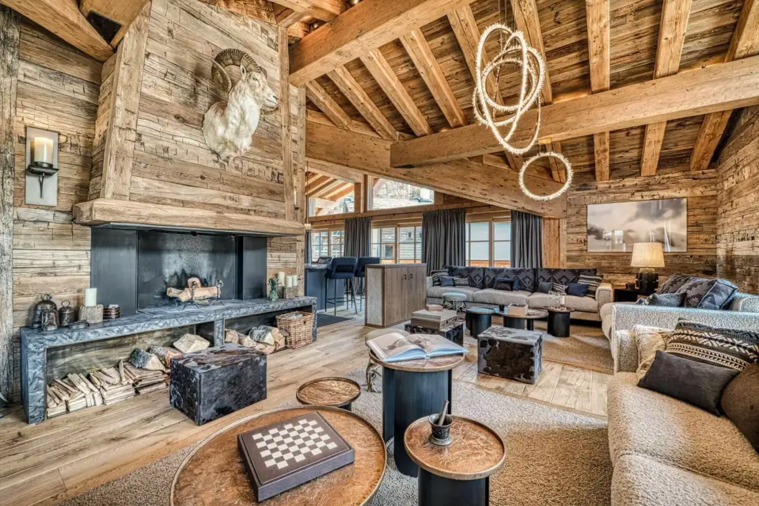 A rustic living room with a stone fireplace and comfortable seating.