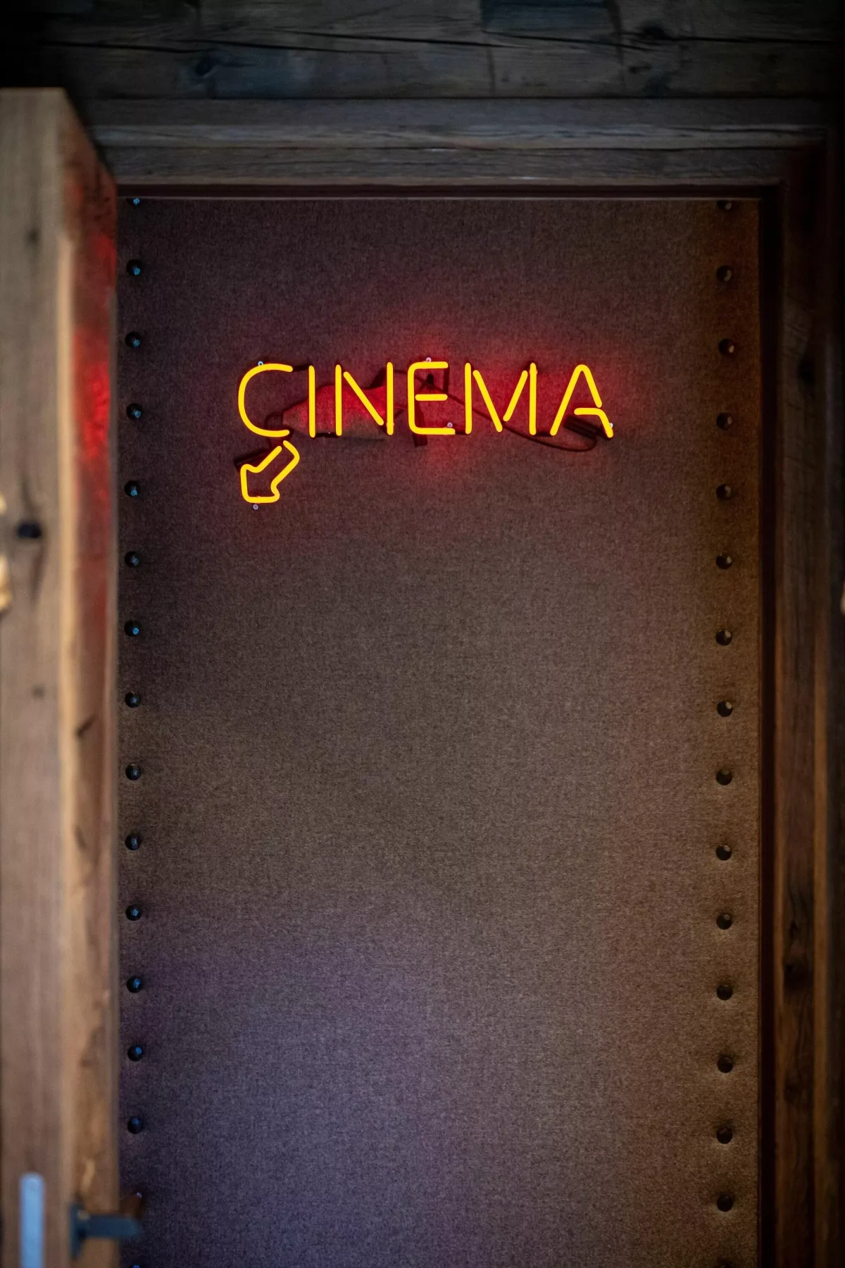 A dark doorway features a glowing neon cinema sign.