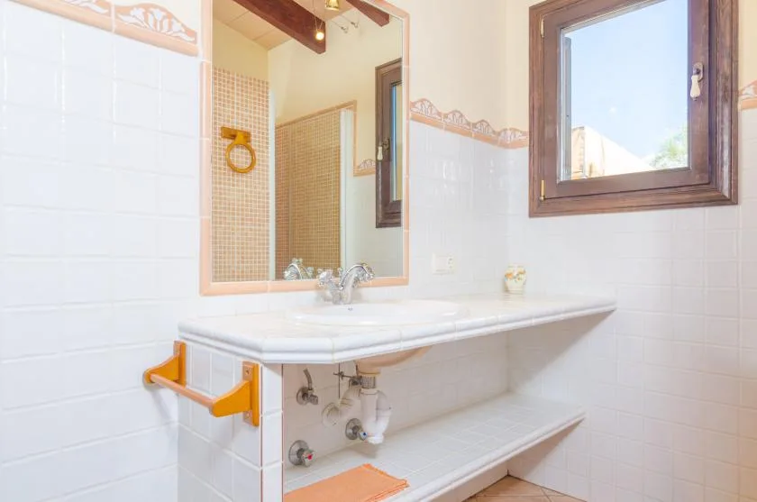 A bathroom vanity with a mirror and open shelving beneath the sink.