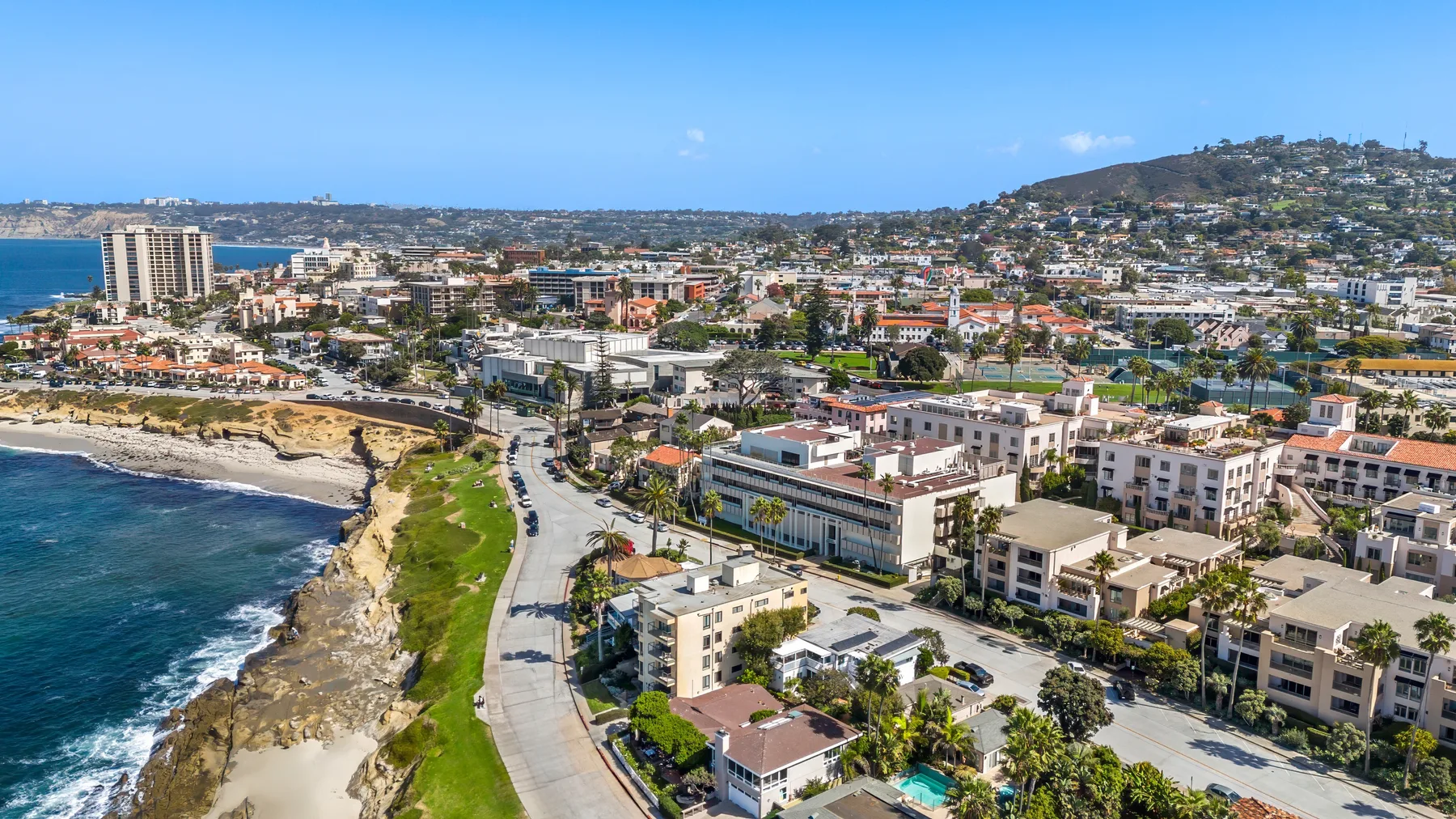 Una ciudad costera con edificios junto a la orilla y una carretera curva.