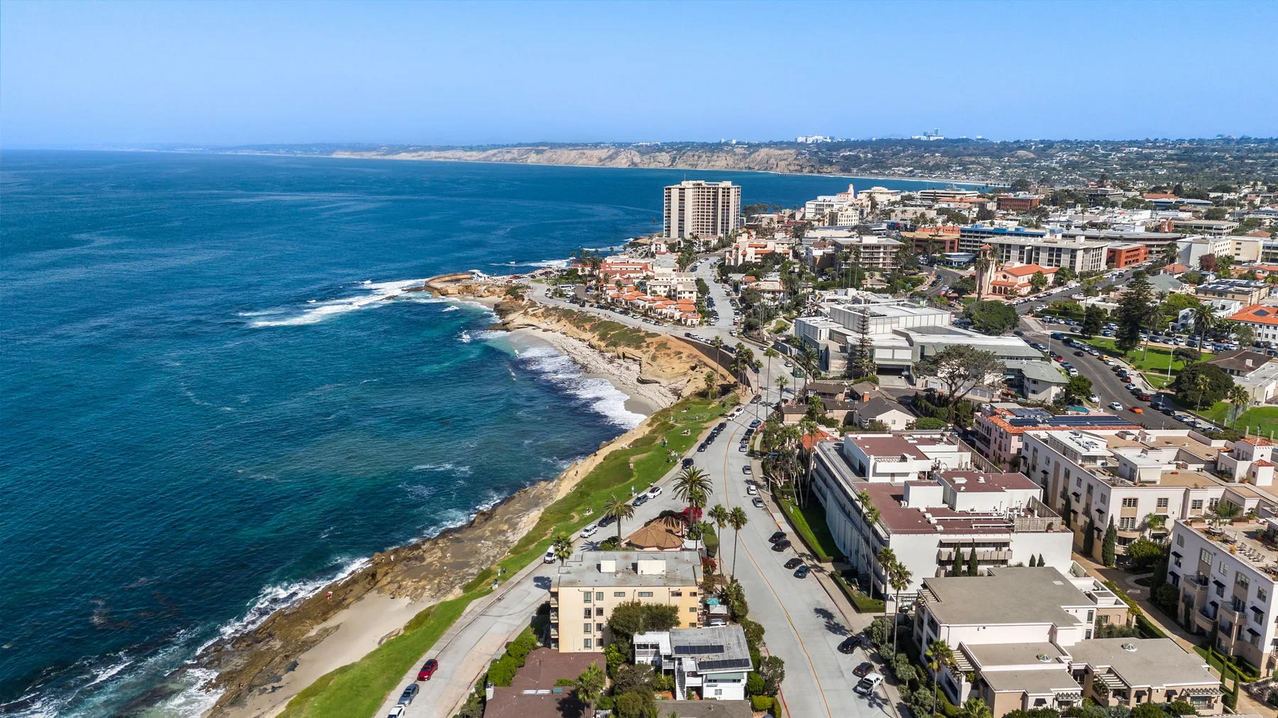 Vista aérea de una ciudad costera, con edificios junto a la costa.