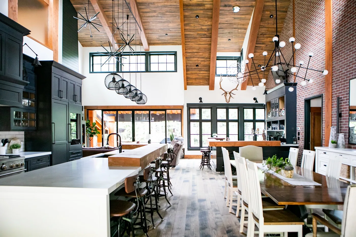 Una amplia cocina y comedor cuentan con una gran isla y una mesa larga.