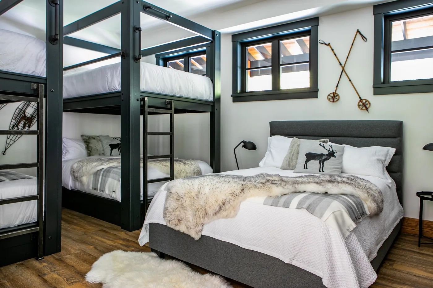 Un dormitorio con una cama doble y literas negras a un lado.