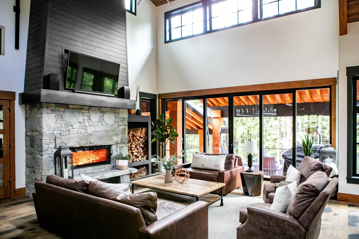 Una sala de estar con asientos alrededor de una mesa de centro y una chimenea de piedra.