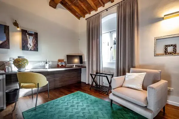 Una zona de estar con escritorio, asiento acolchado y una ventana.