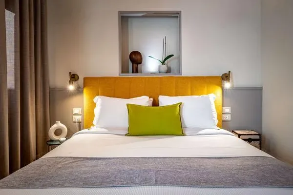Un dormitorio con una cama bien tendida y un cabecero amarillo brillante.