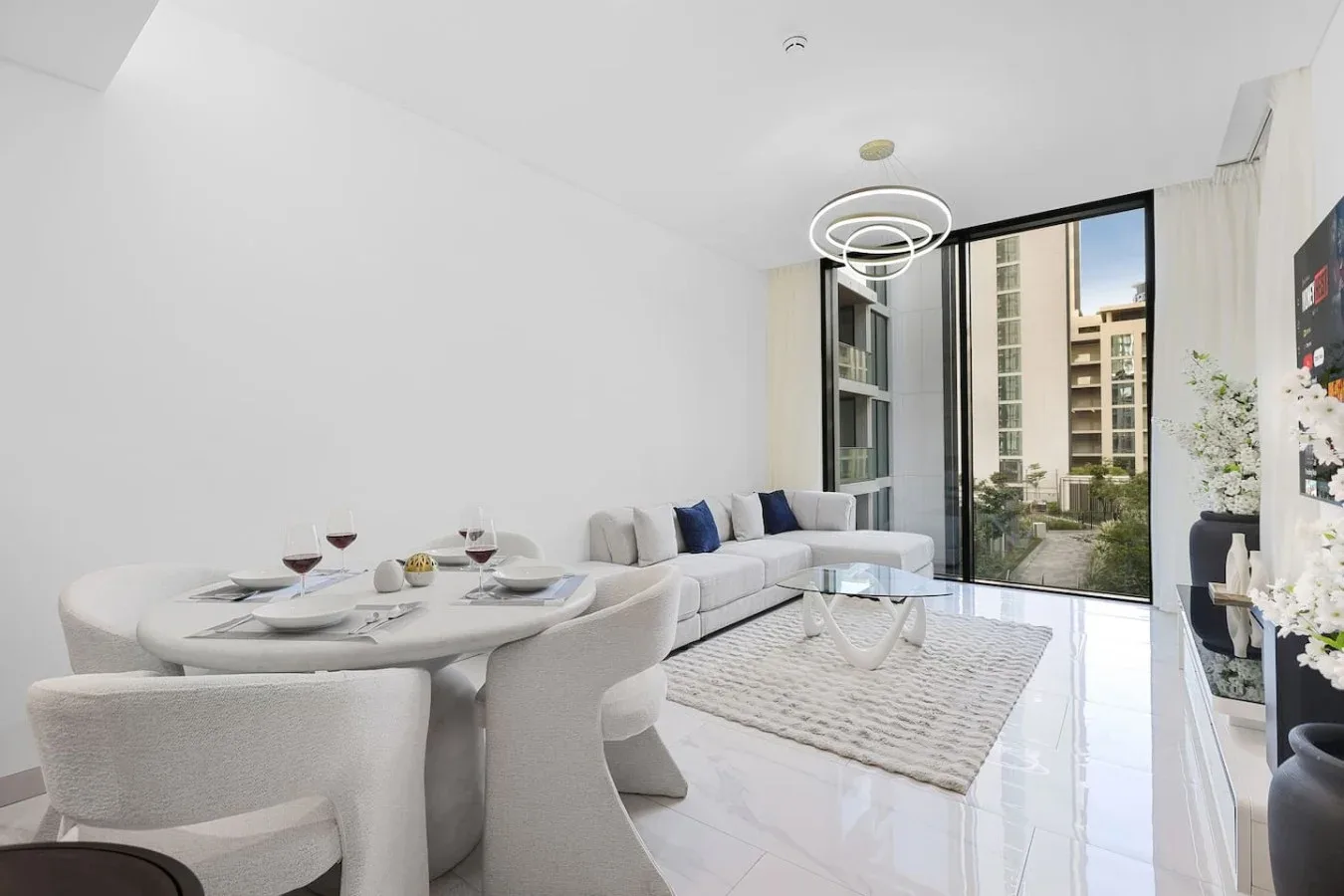 Una sala luminosa con mesa de comedor y asientos junto a ventanales.