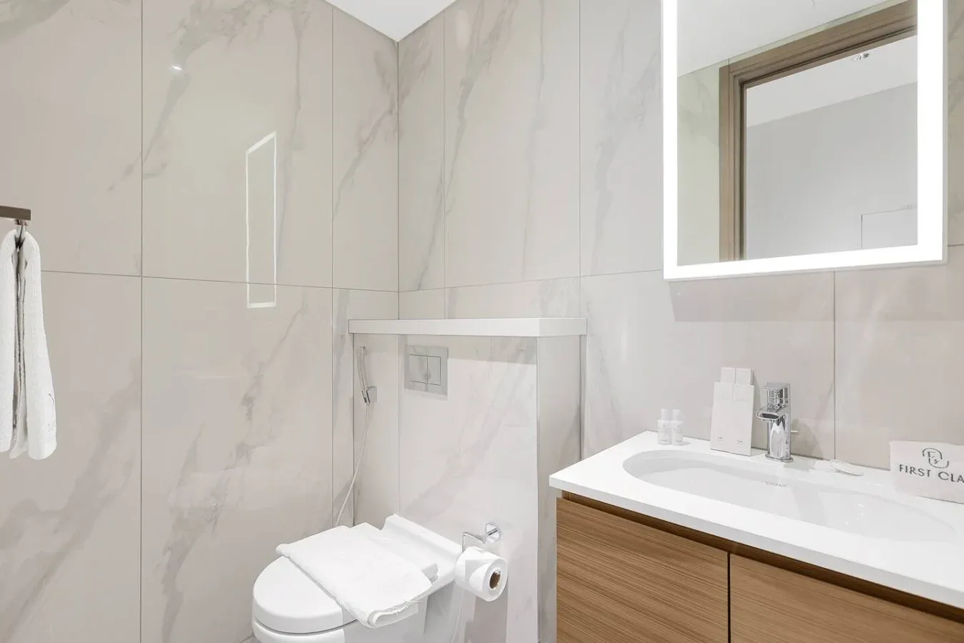 Un baño alicatado con inodoro, ducha de vidrio y lavabo.