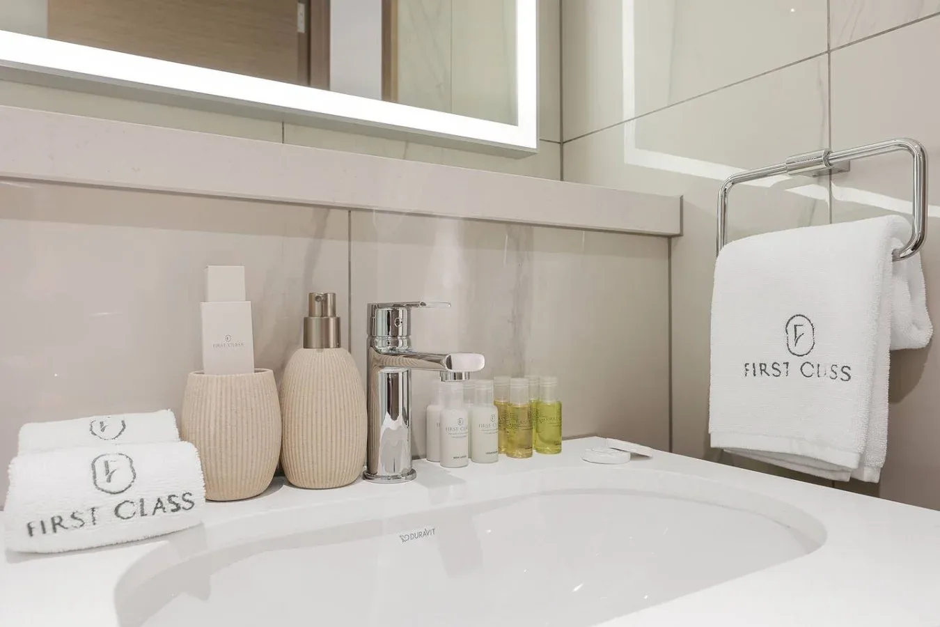 Un lavabo de baño con artículos de aseo y toallas dobladas.