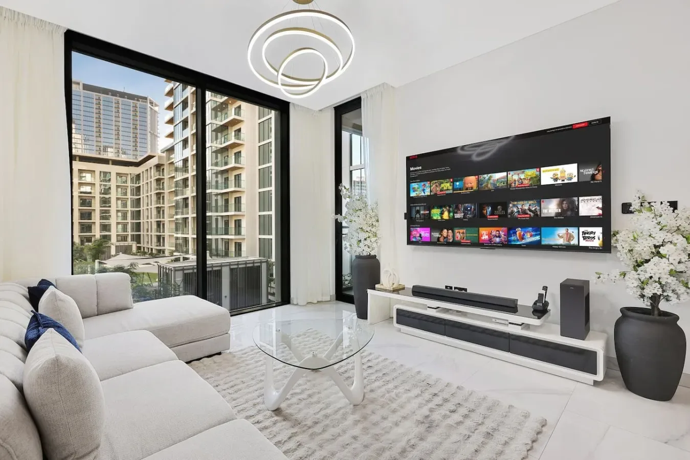 A bright living room with a sectional seating area and television.