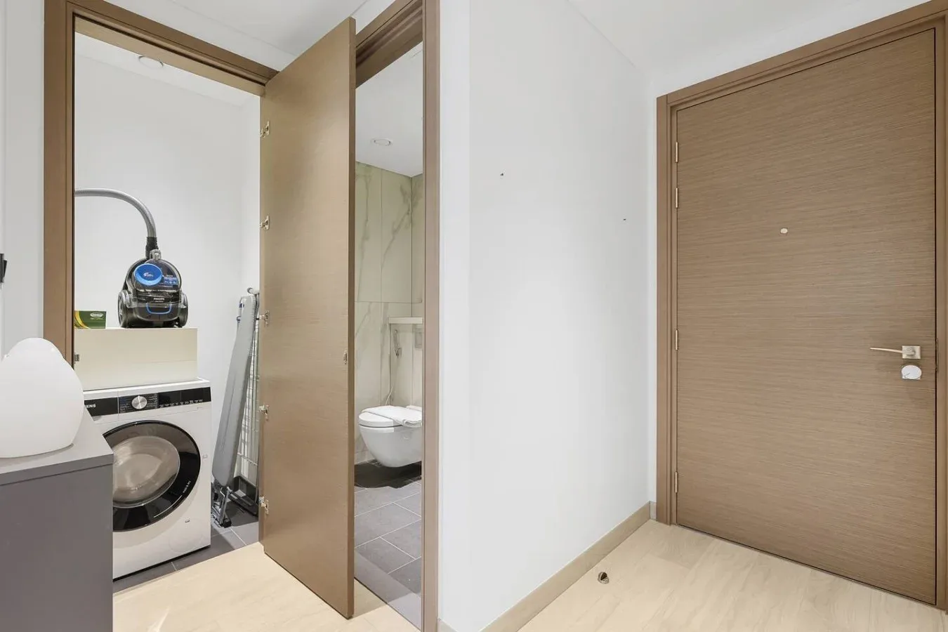 Un baño con una lavadora junto a una zona de ducha abierta.