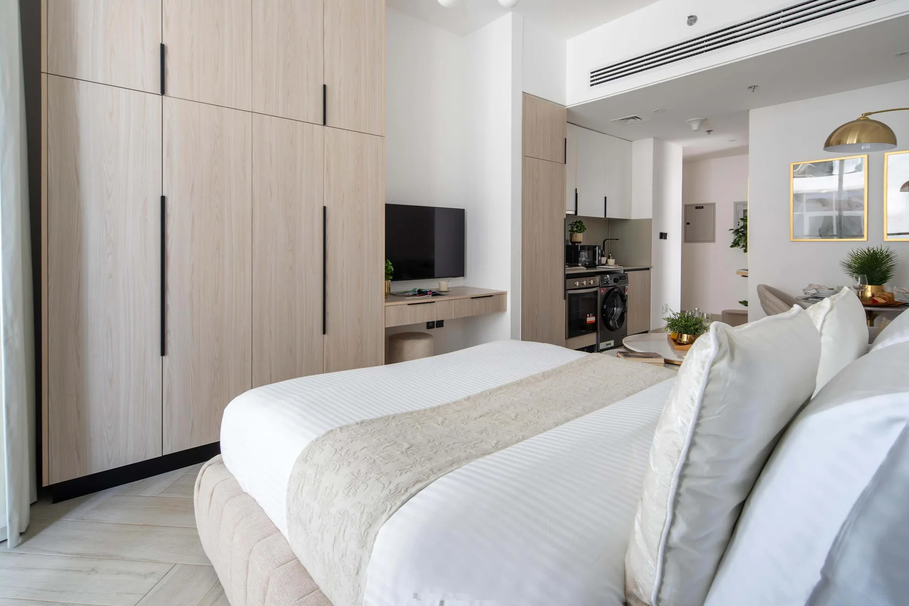 A bright bedroom with a neatly made bed and built-in wardrobes.