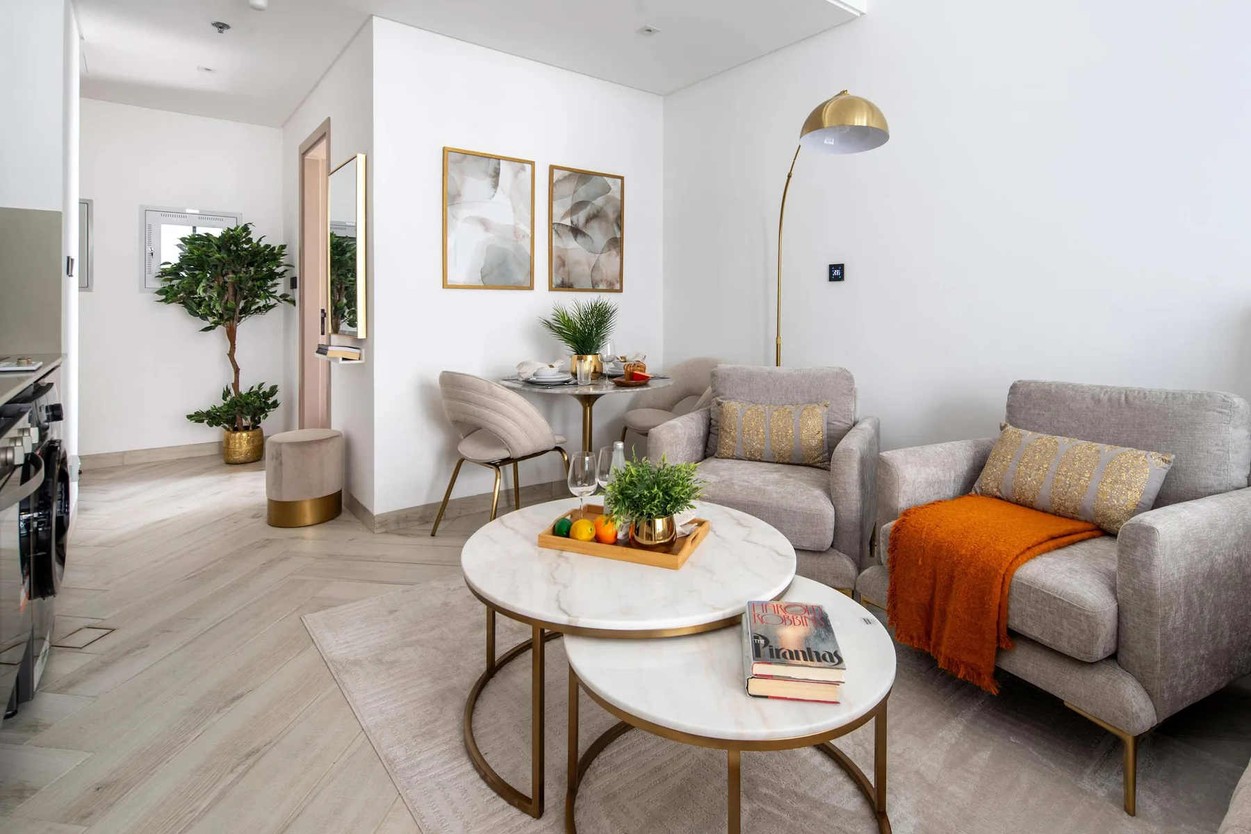A bright living room with gray seating and round coffee tables.
