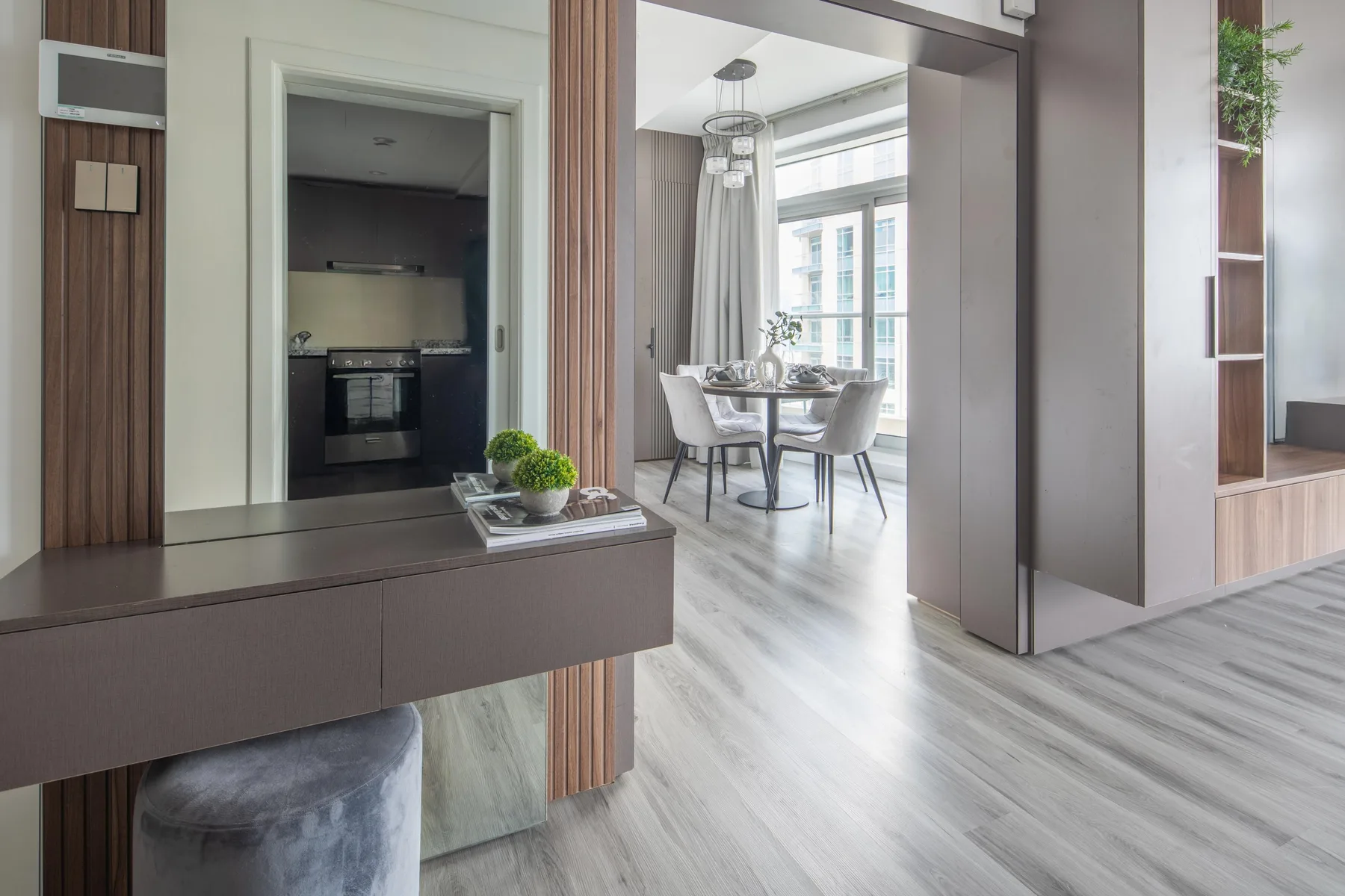 Un comedor con mesa y sillas está junto a una cocina y un recibidor.