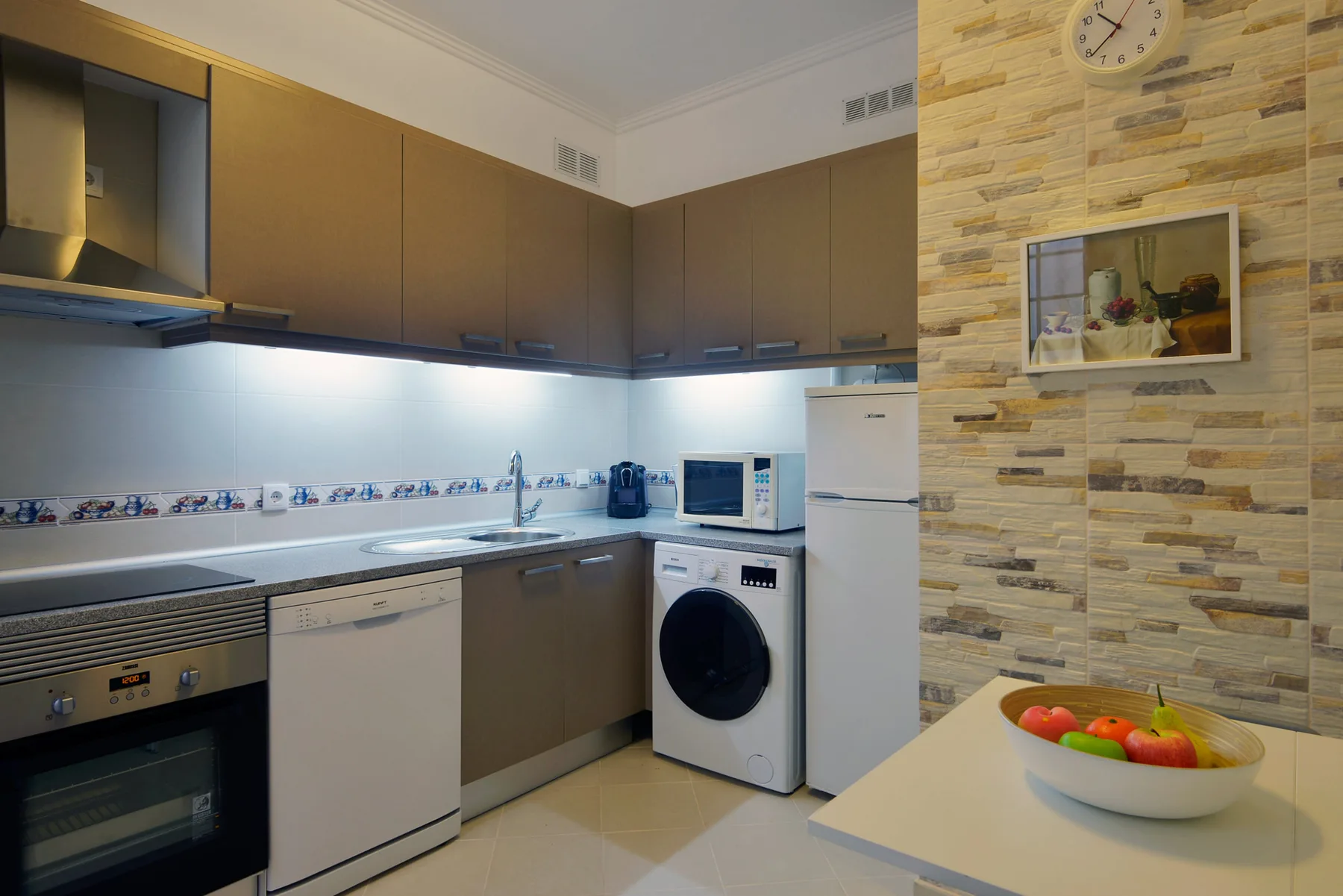 Una cocina moderna con gabinetes marrones y una encimera.