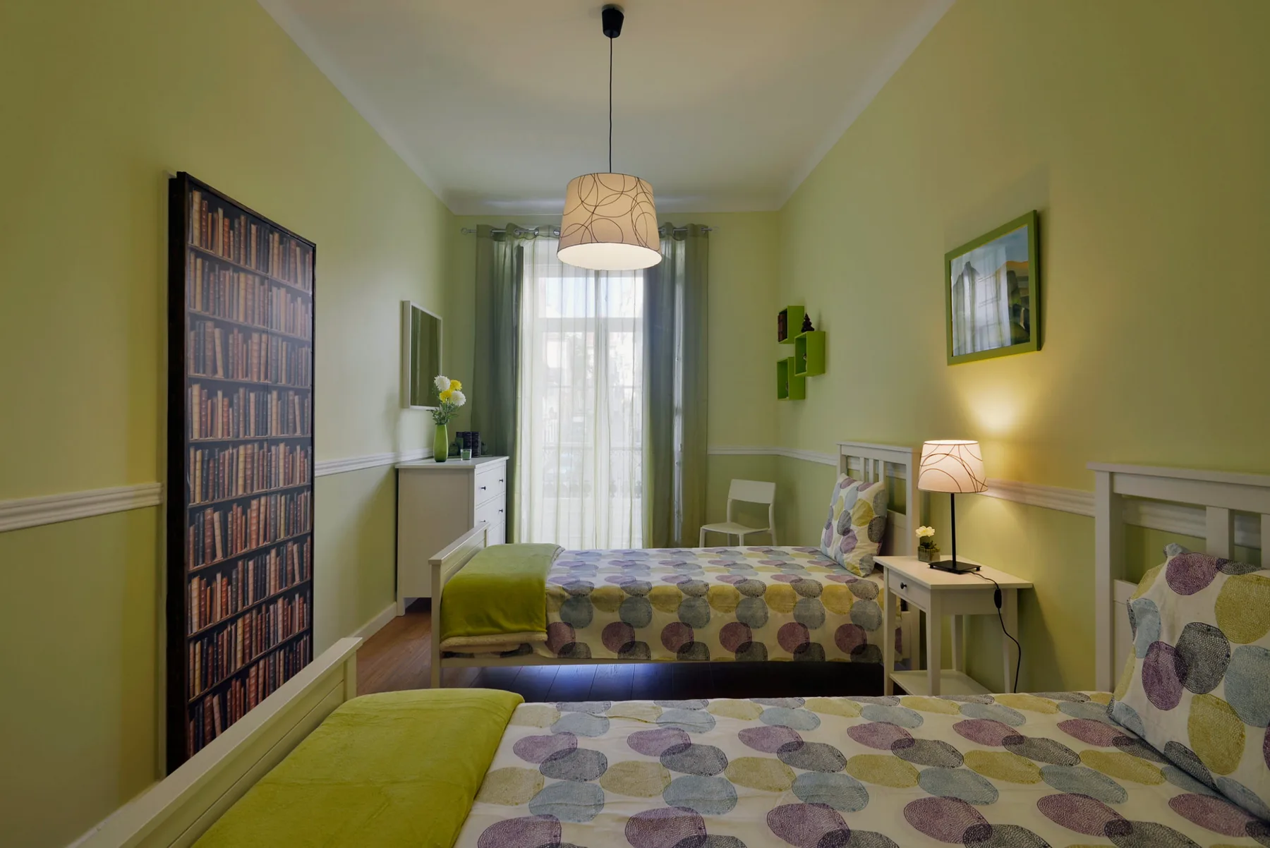Un dormitorio con dos camas vestidas con ropa de cama estampada y colorida.