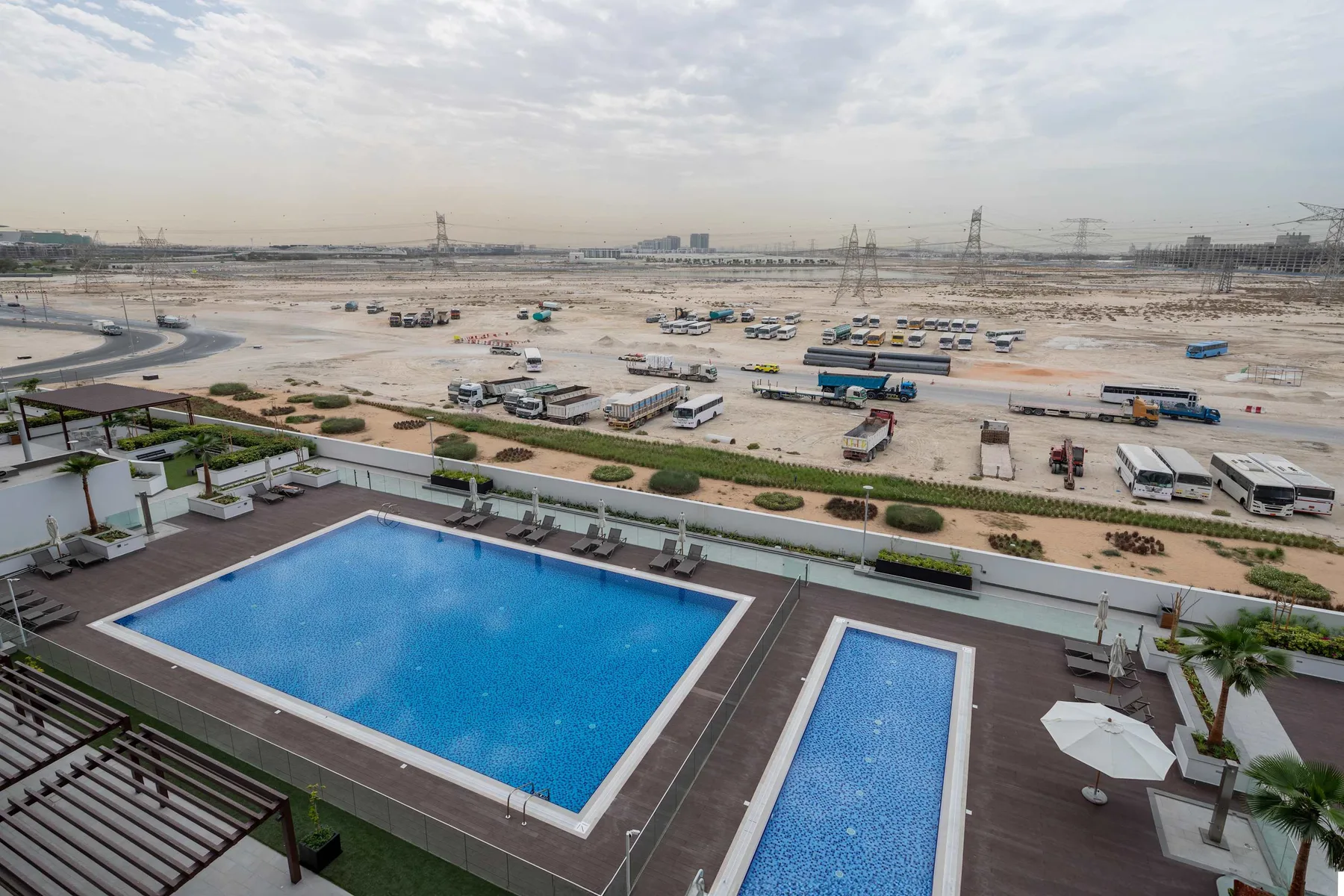 Una terraza con piscina al aire libre da a una amplia zona de obras.
