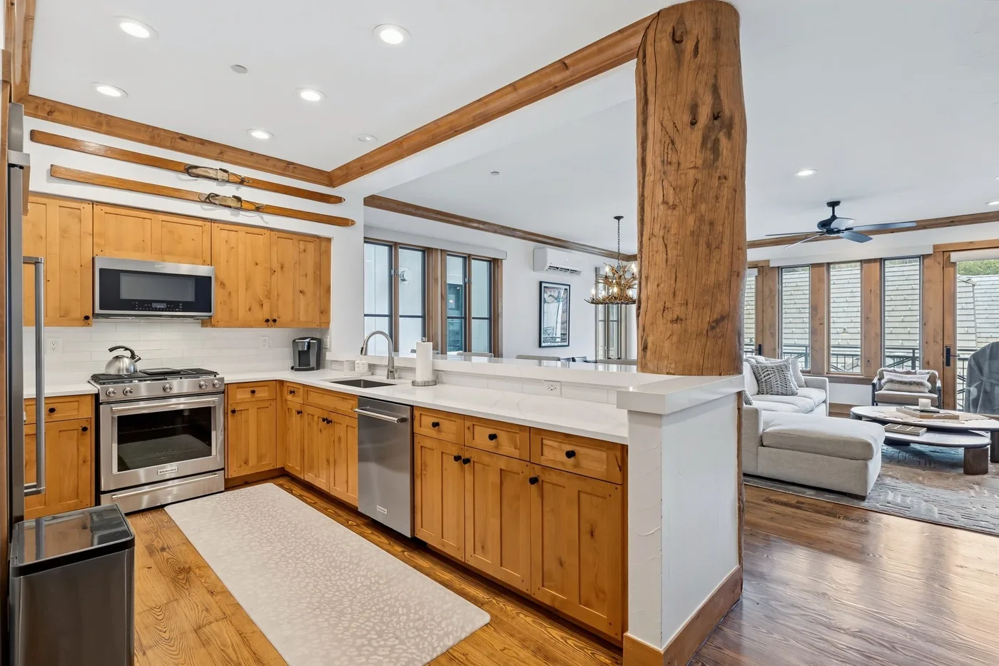 An open-plan kitchen and living area with wood cabinetry and a central island.