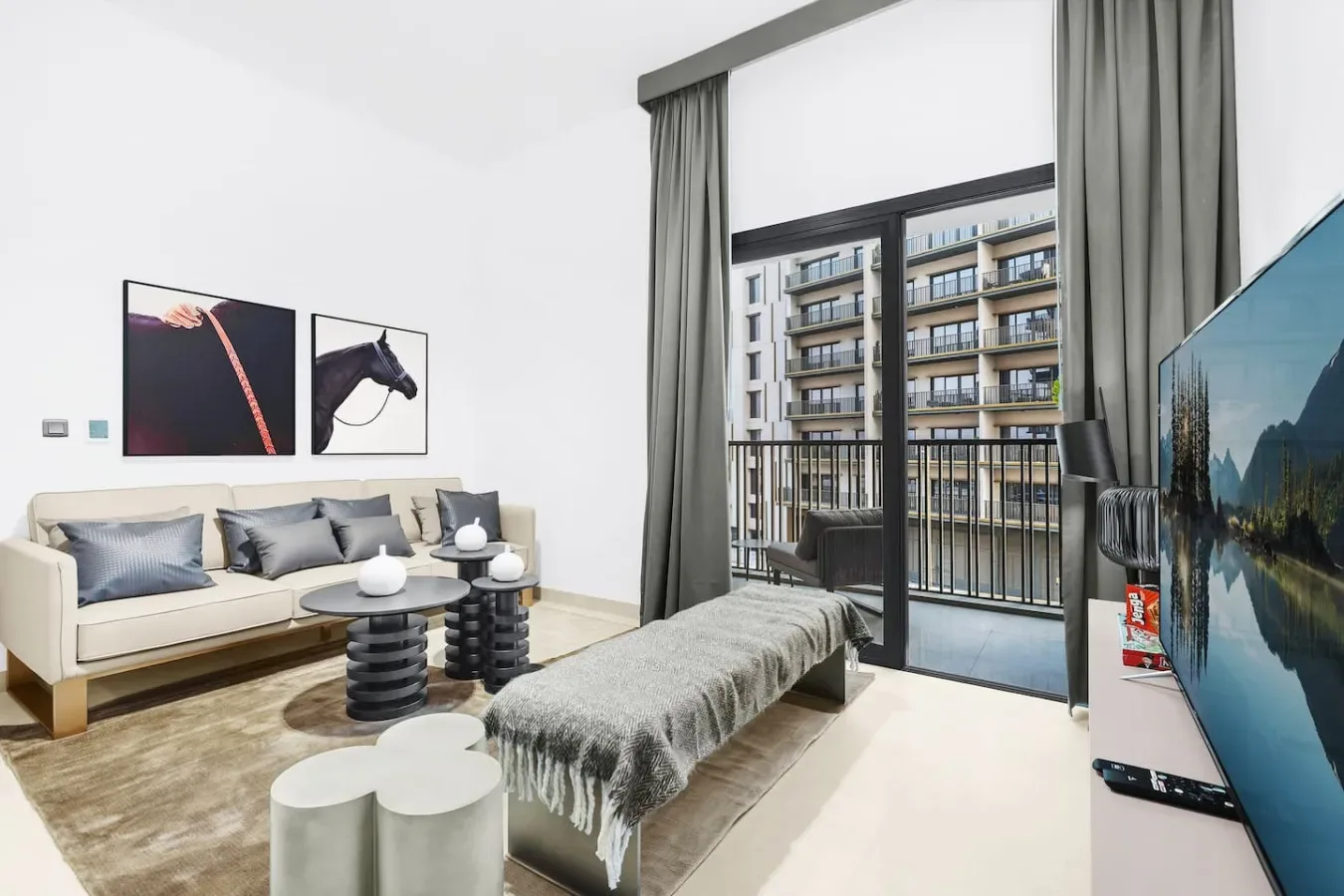 A bright living room with seating, a coffee table, and a balcony view.