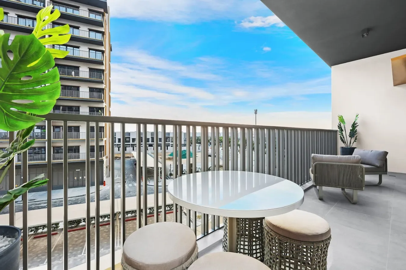 A balcony seating area with a round table and views of nearby buildings.