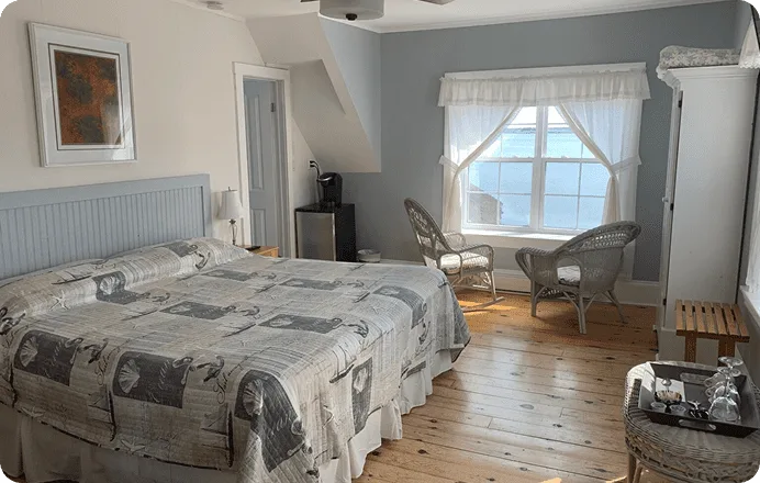 Guest bedroom with wood flooring and a window.