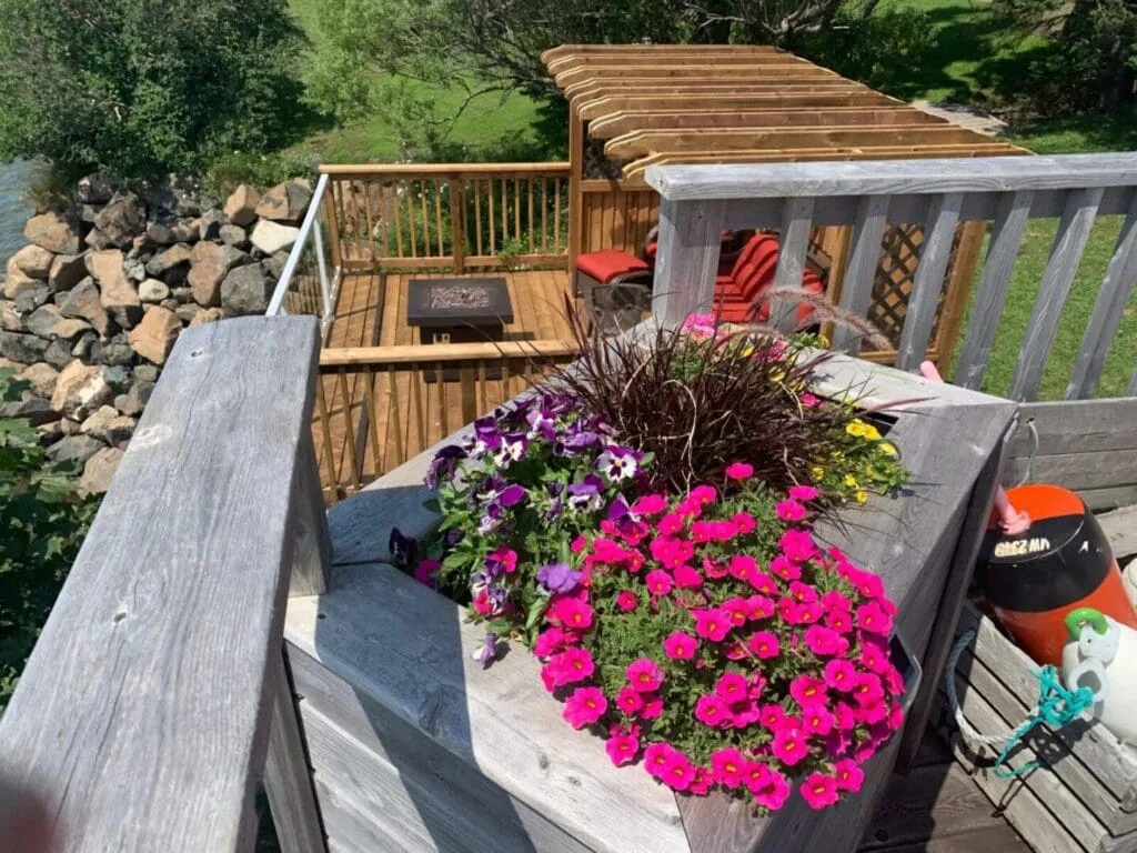 Deck with flowers and a wooden pergola.