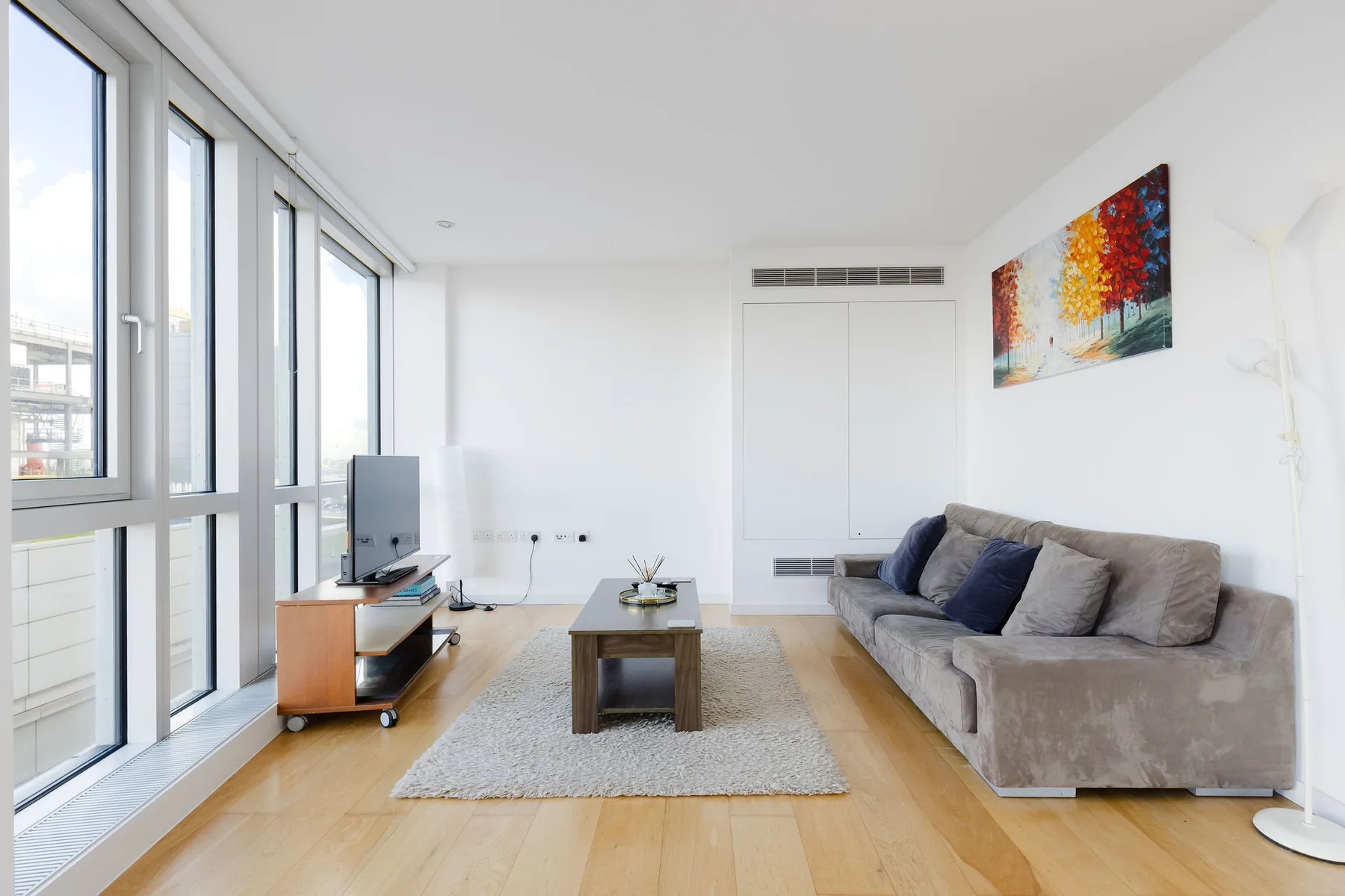 A bright living room with a gray sofa and a coffee table.