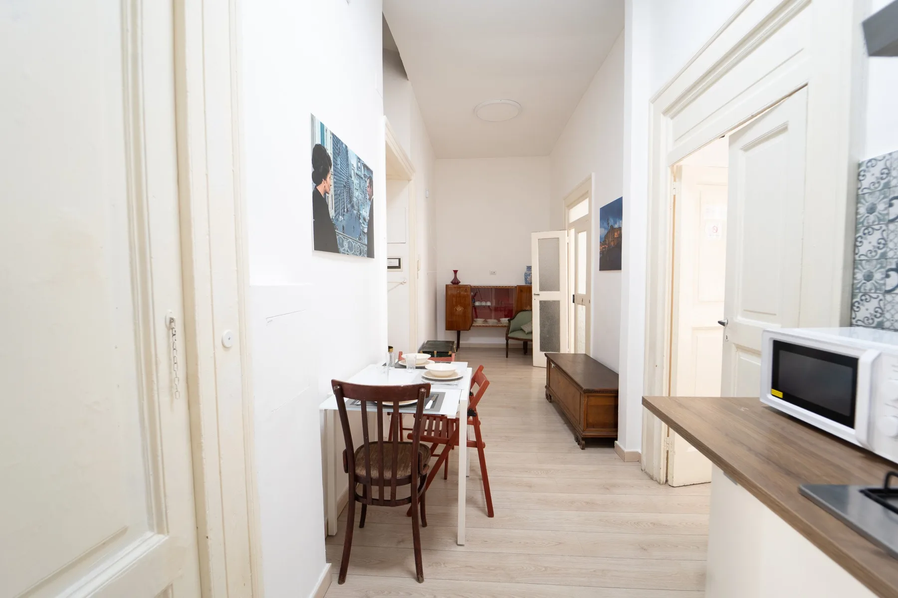 Un comedor luminoso con una mesa y sillas junto a una encimera de cocina.
