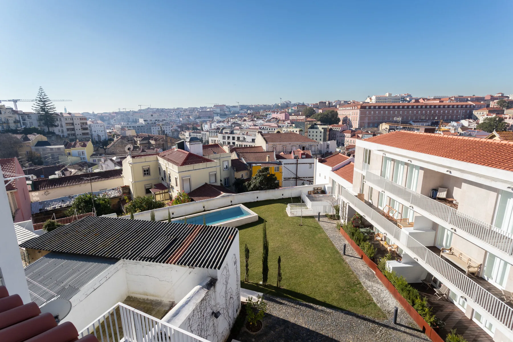 A cityscape view overlooks nearby buildings and a courtyard garden.