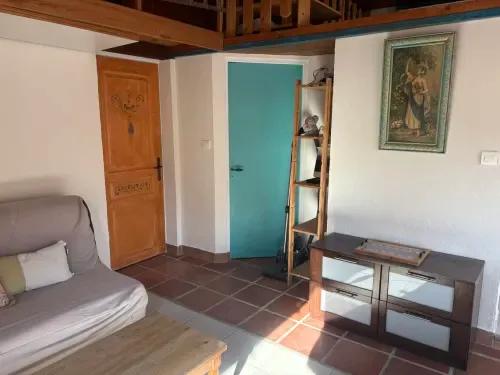 Grand Gîte living room with turquoise door and wooden furniture.