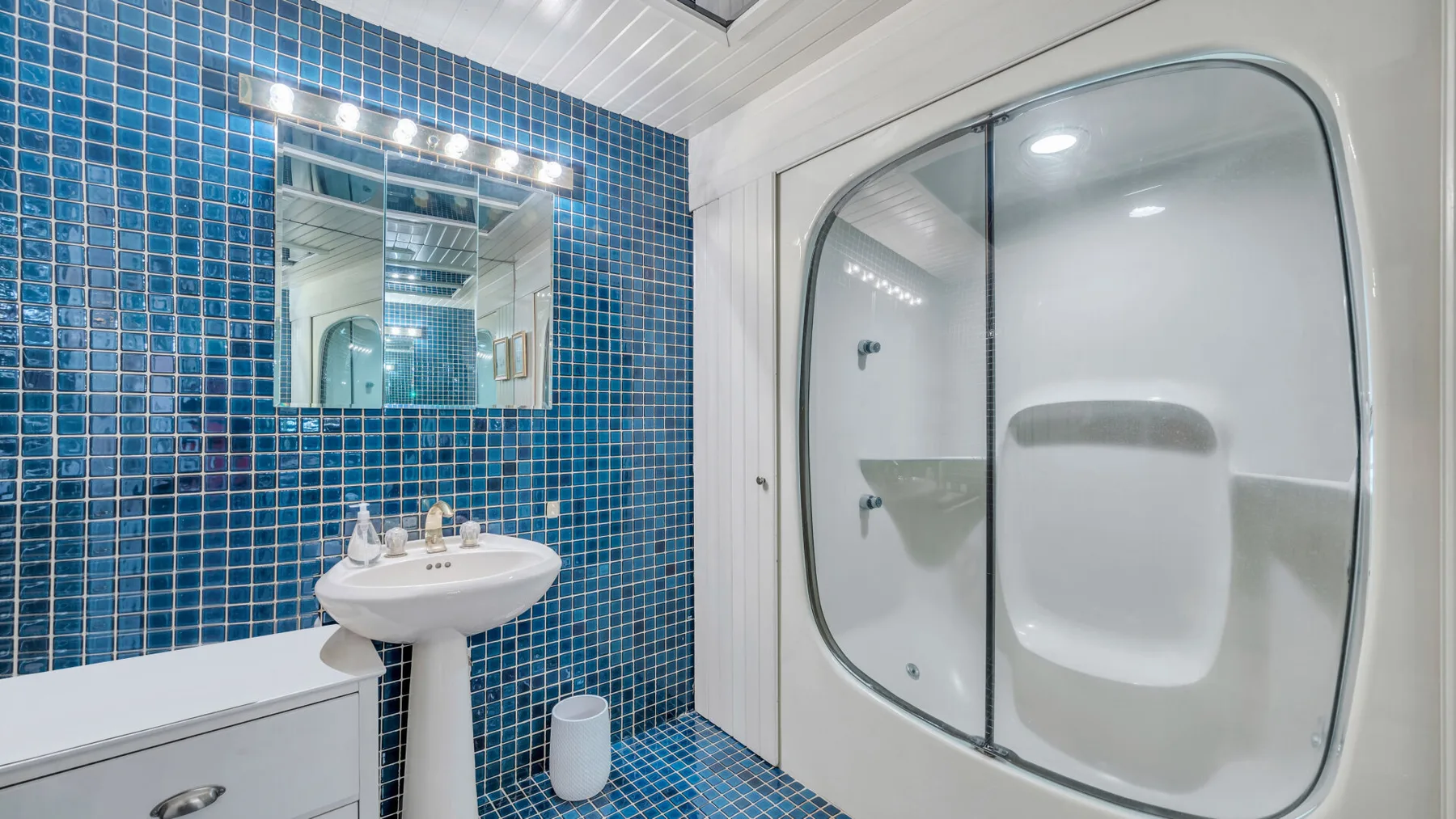 Un baño con lavabo, espejo y ducha.