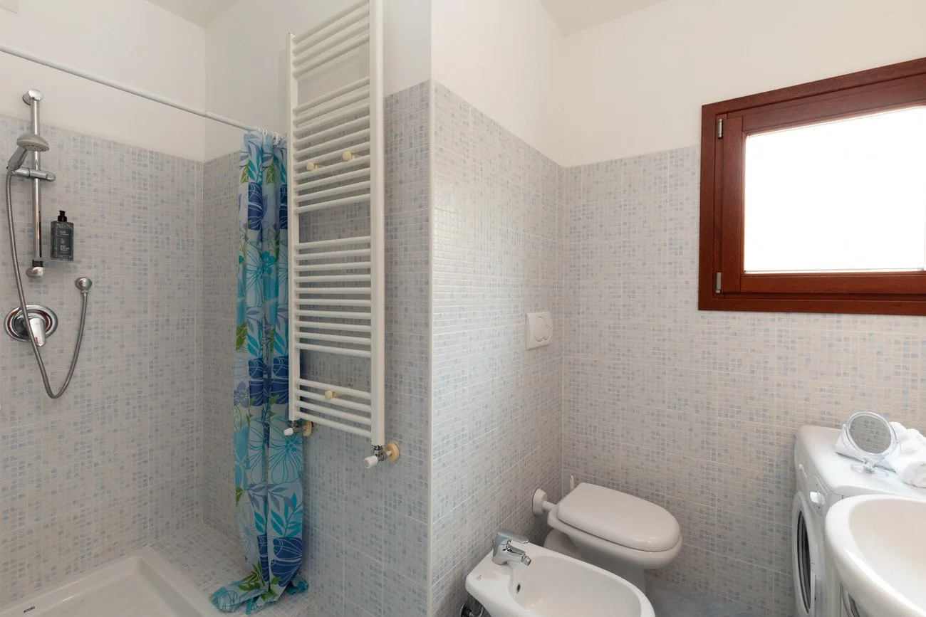 Un baño alicatado con ducha, inodoro y bidé.