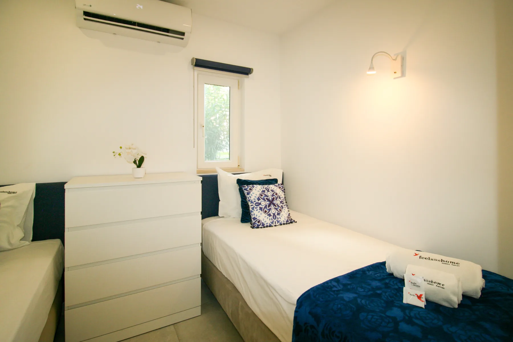 Un dormitorio luminoso con una cama individual, una cómoda y una ventana.
