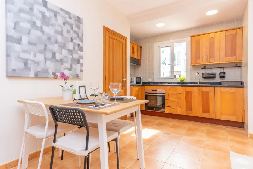 A dining area beside a kitchen, with a table set near the countertop.