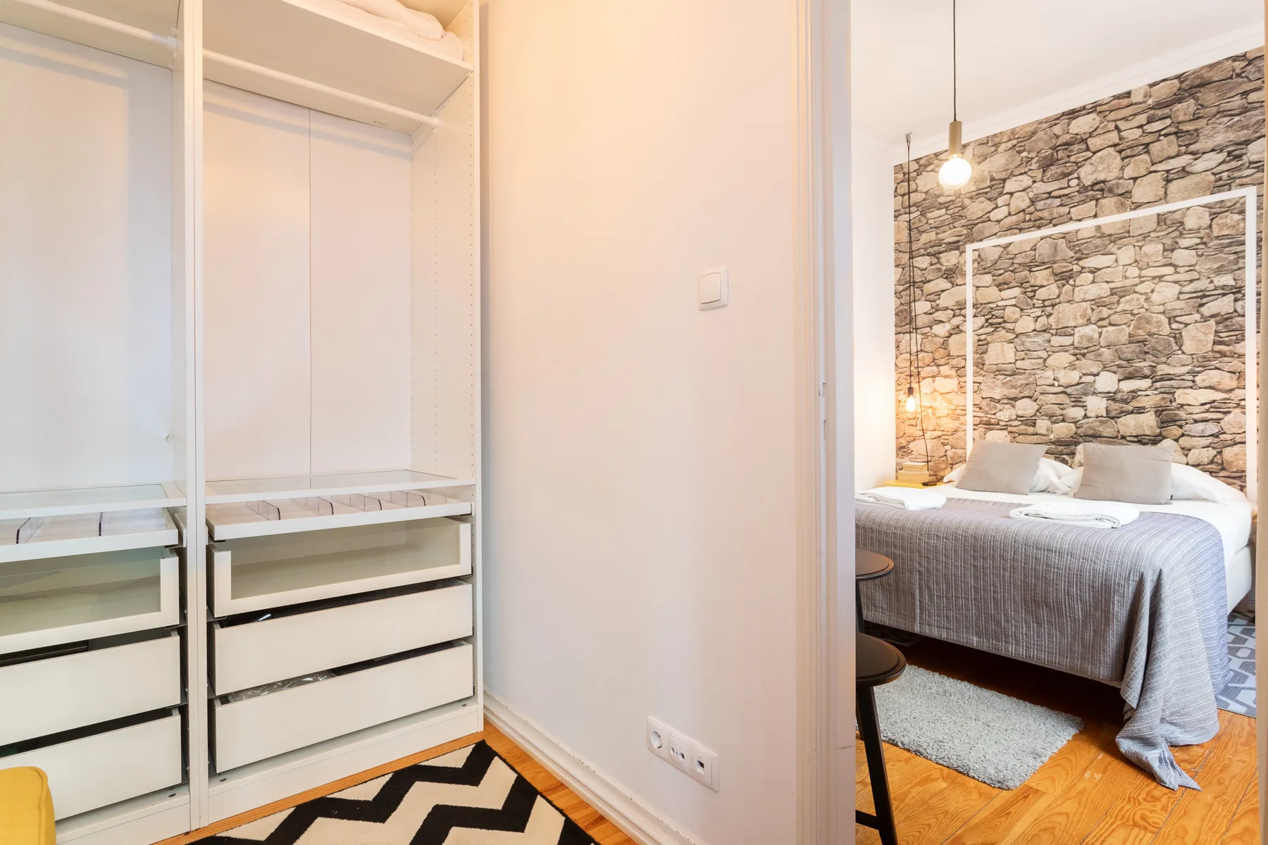 Se ve un dormitorio a través de una puerta abierta, junto a un armario empotrado.