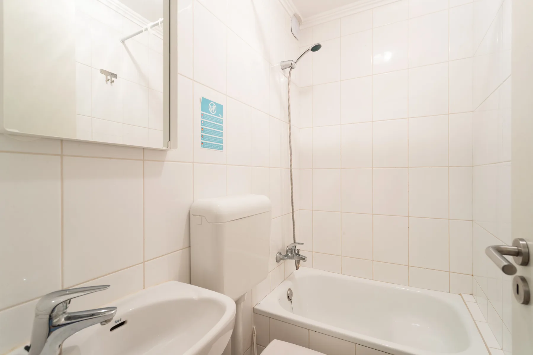 Baño alicatado con bañera, ducha y lavabo.