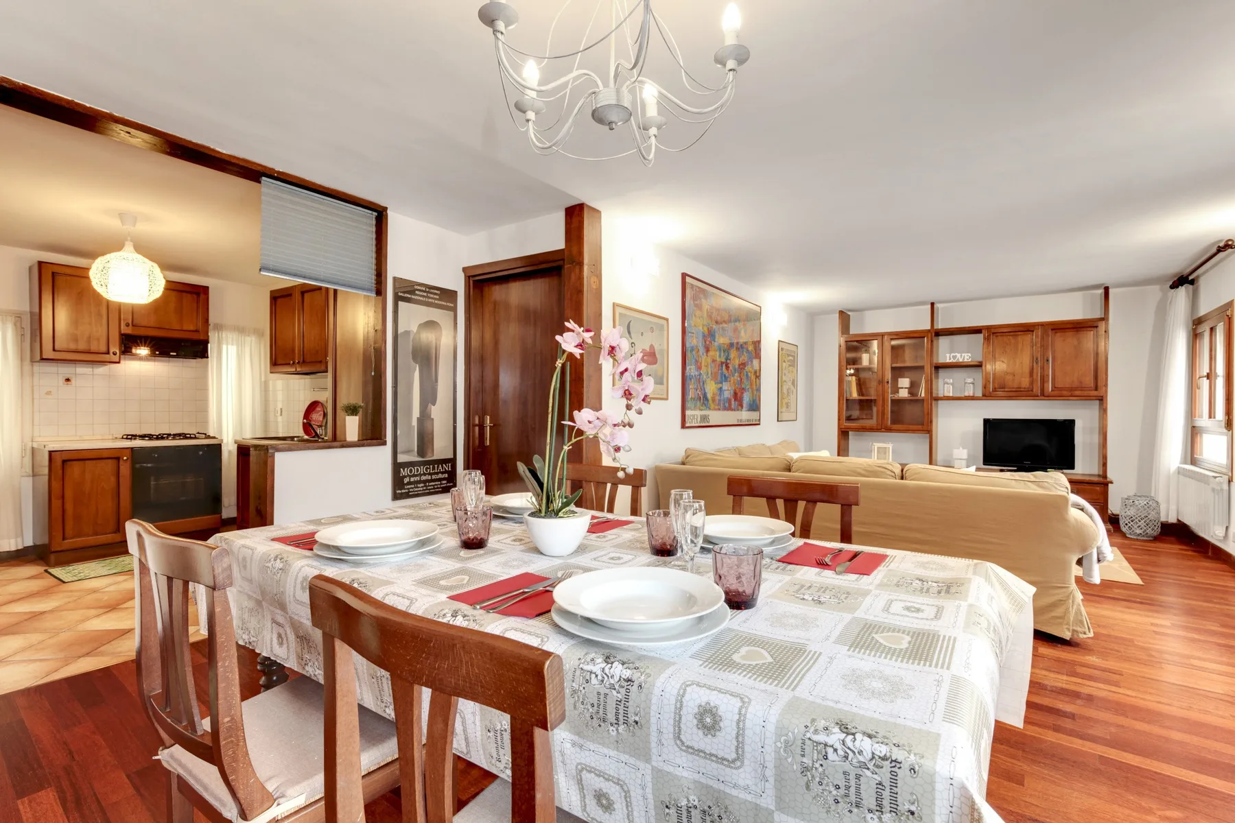 El comedor se abre a una cocina y una sala de estar, con la mesa puesta.
