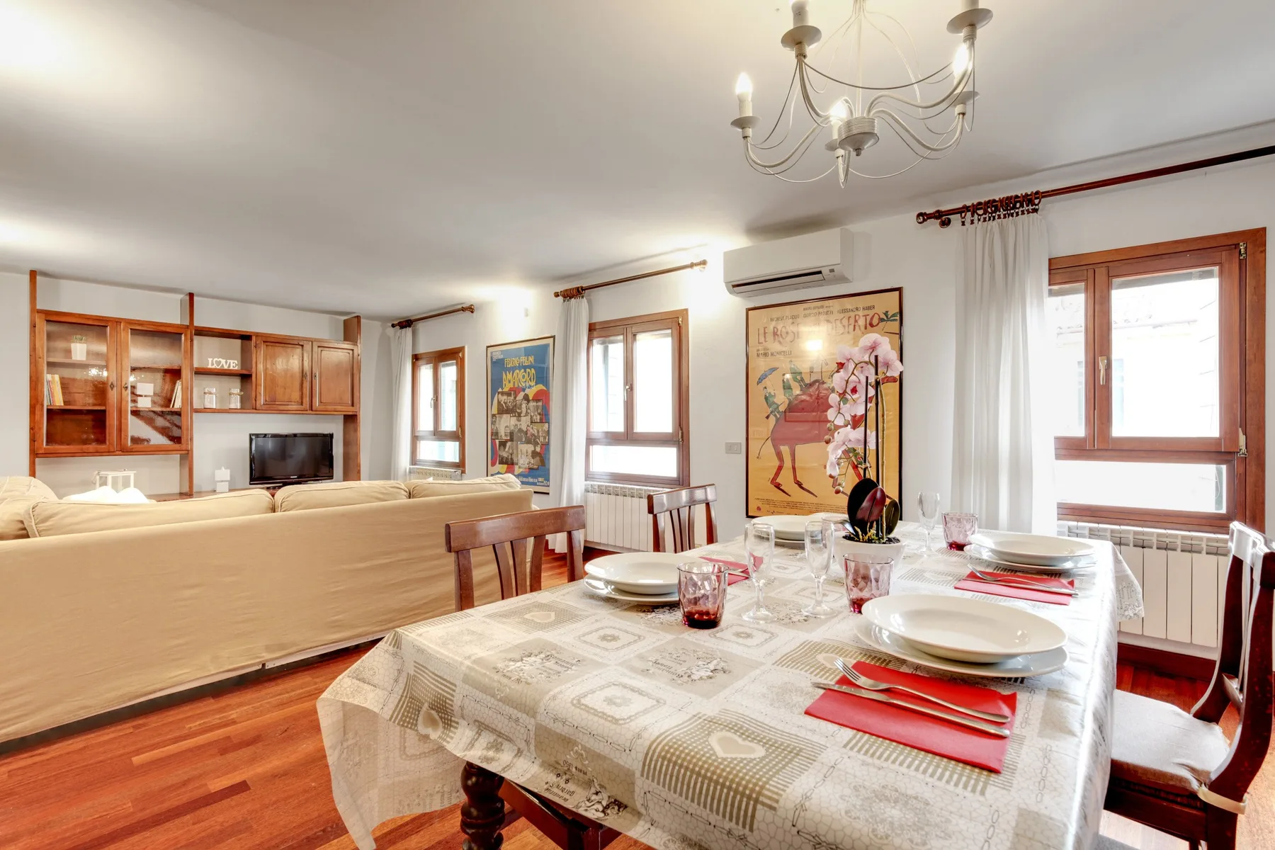 Un comedor luminoso con la mesa puesta junto a una zona de estar.